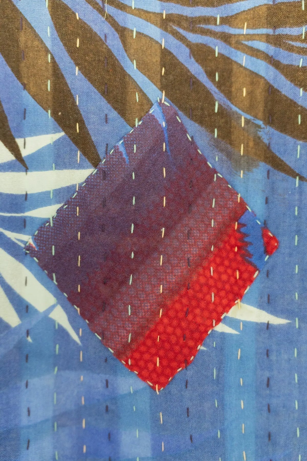 a blue and red kantha throw blanket stitching up close