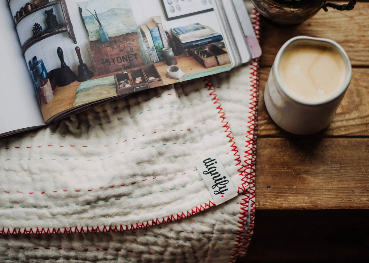 Cozy reading nook with a kantha throw blanket, a cup of coffee and a good book
