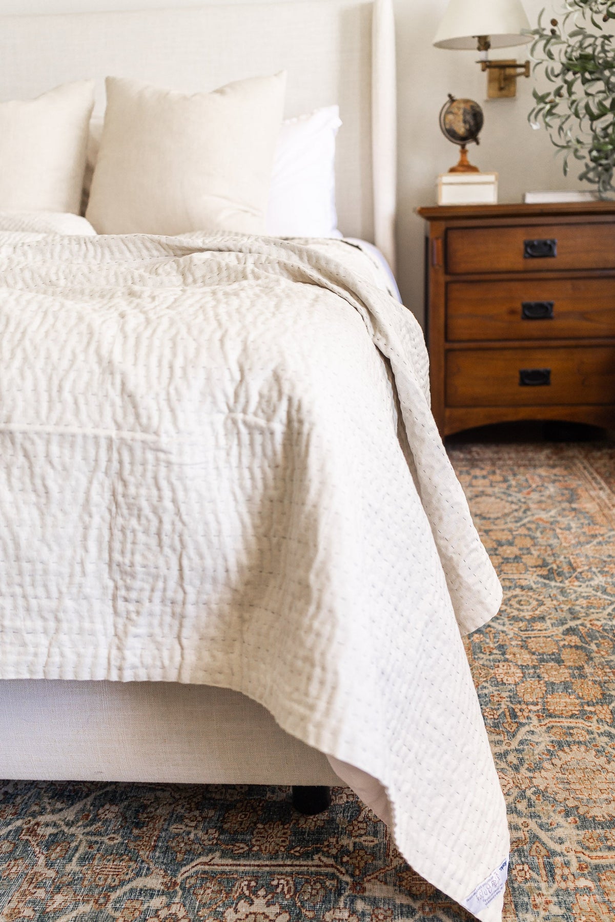 hand-stitched white kantha quilt on queen bed